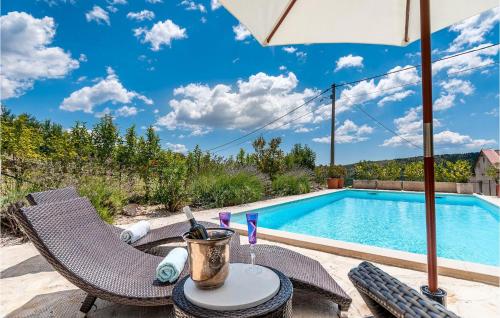 a table and chairs with an umbrella next to a swimming pool at Villa Amore in Bribir