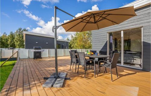 a patio with a table with chairs and an umbrella at 3 Bedroom Amazing Home In Rødby in Rødby