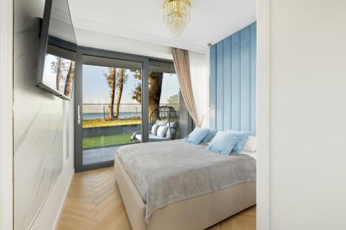 a bedroom with a bed and a large window at Apartament Holiday Gold in Rewal