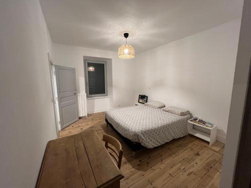 une chambre avec un lit et une table dedans dans l'établissement Maison dans le parc des volcans, à Saint-Genès-Champanelle
