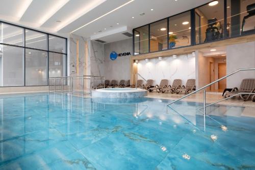 a pool in a room with a large blue pool at Apartament Holiday Gold in Rewal