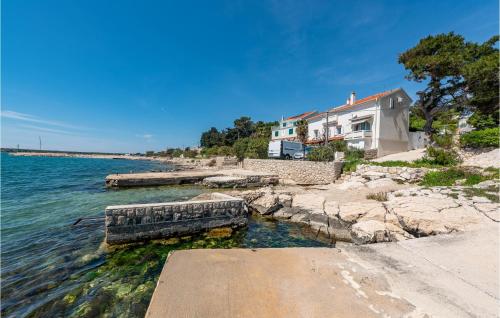 a house on the shore of a body of water at 2 Bedroom Gorgeous Apartment In Kosljun in Košljun