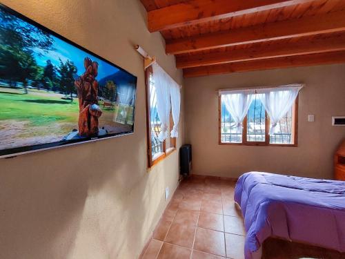 a bedroom with a flat screen tv on the wall at Monoambiente Buena Vista - De Alojamientos Lago Puelo in Lago Puelo