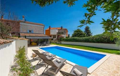 a swimming pool with chairs and a house at Villa Casa Lampadina in Poreč