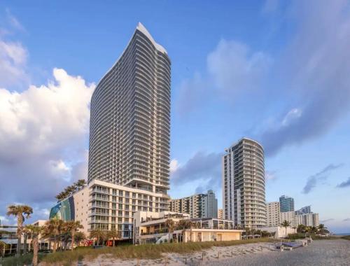 two tall skyscrapers in a city next to a beach at Lyfe Residence Building - Private apts over the beach in Hollywood