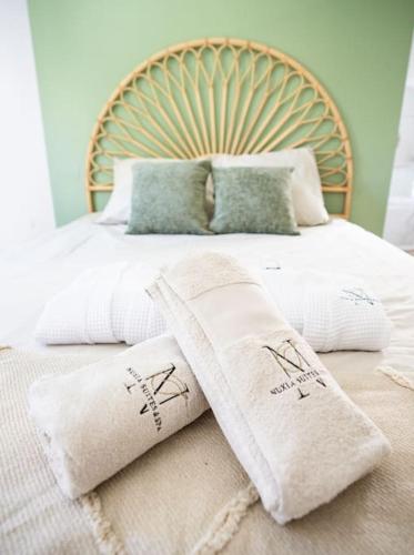 a bed with white towels on top of it at NUXIA Suites&SPA L'Abohème Chic in Bagnols-sur-Cèze