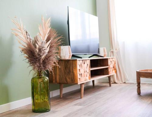 a vase with plants in it next to a dresser at NUXIA Suites&SPA L'Abohème Chic in Bagnols-sur-Cèze