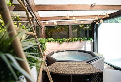 a patio with a table and a hot tub at NUXIA Suites&SPA L'Abohème Chic in Bagnols-sur-Cèze