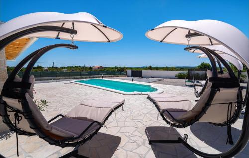 patio z 2 krzesłami, parasolem i basenem w obiekcie Nice Home In Zemunik Donji With Wifi w mieście Malić