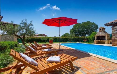 a group of chairs and an umbrella next to a swimming pool at Villa Marco in Rovinj