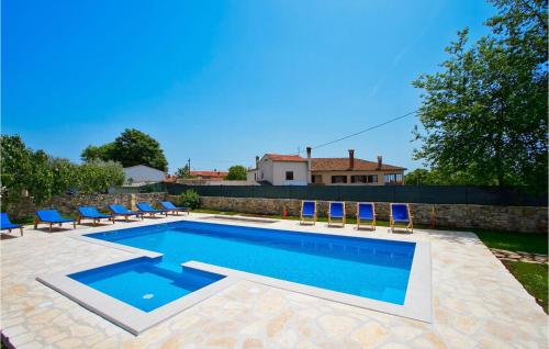 a swimming pool with blue chairs and a house at Villa Soricevi Dvori in Barat