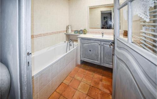 a bathroom with a tub and a sink and a mirror at Nice Home In Venasque With Kitchen in Venasque