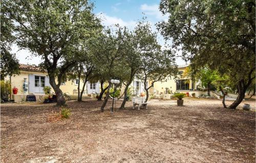 a park with a bench and trees in front of a house at Nice Home In Venasque With Kitchen in Venasque