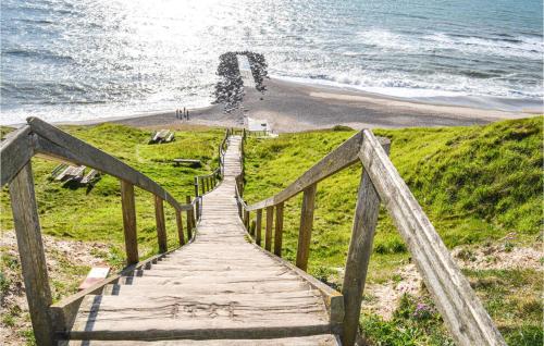 a wooden boardwalk leading to a beach and the ocean at Holiday Home Lemvig 12 in Lemvig