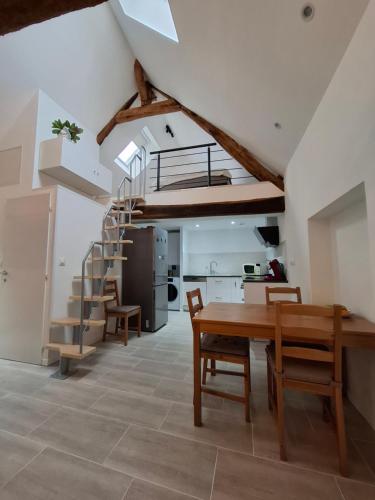 a kitchen and dining room with a wooden table and stairs at - La Maison Authentique - 200 m du centre ville et proche d'Orléans in Jargeau