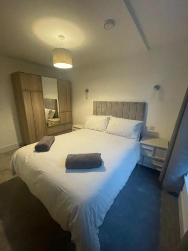 a bedroom with a large bed with a pillow on it at The Duplex at Sophia Mews with free parking in Cardiff