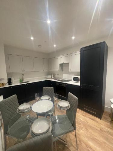 a kitchen with a table with four chairs and a black refrigerator at The Duplex at Sophia Mews with free parking in Cardiff