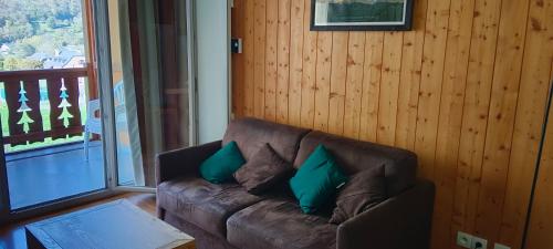 a living room with a brown couch with green pillows at LUZVAL Duplex avec Balcon in Luz-Saint-Sauveur
