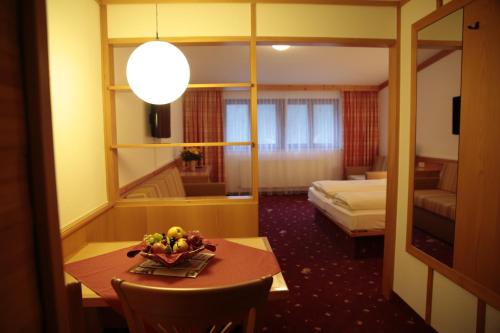 a hotel room with a table with a bowl of fruit on it at Alpensporthotel Mutterberg in Mutterbergalm