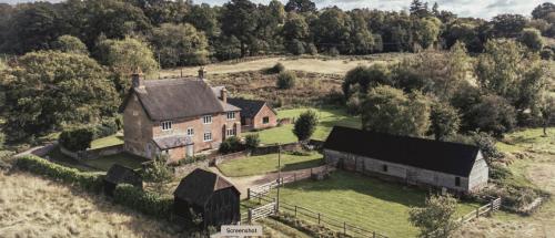 an aerial view of an old house in a field at Gorgeous English Farmhouse Holiday Cottage for 9 and a half in Ellingham