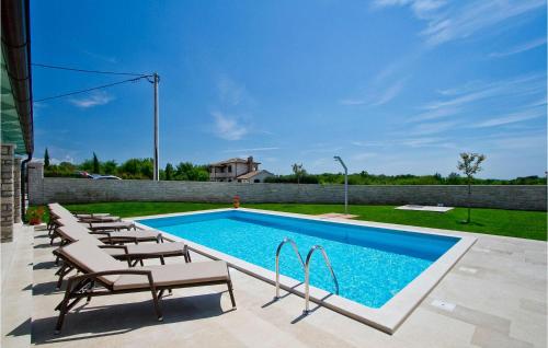 a swimming pool with lounge chairs next to a fence at Villa Luca in Radetići