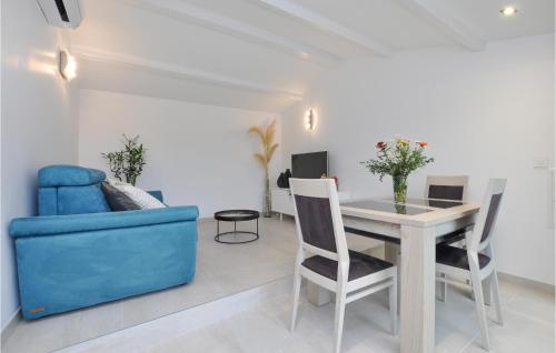 un salon avec un canapé bleu, une table et des chaises dans l'établissement Awesome Home In Cavalaire-Sur-Mer, à Cavalaire-sur-Mer