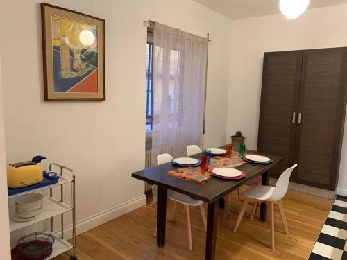 a dining room with a table and white chairs at Casa Mentana in Terni