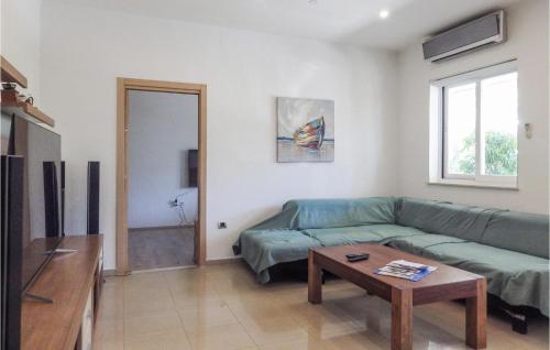a living room with a green couch and a table at 1 Bedroom Beautiful Apartment In Cavtat in Cavtat