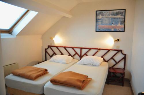 two twin beds in a room with a window at Résidence Durbuy in Durbuy