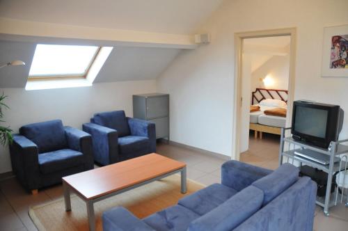 a living room with a couch and two chairs and a tv at Résidence Durbuy in Durbuy