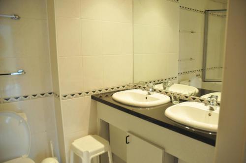 a bathroom with two sinks and a toilet and a mirror at Résidence Durbuy in Durbuy