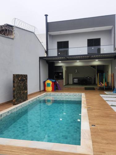 a large swimming pool in a building with a house at Sobrado novo e lindo com piscina in São José dos Campos