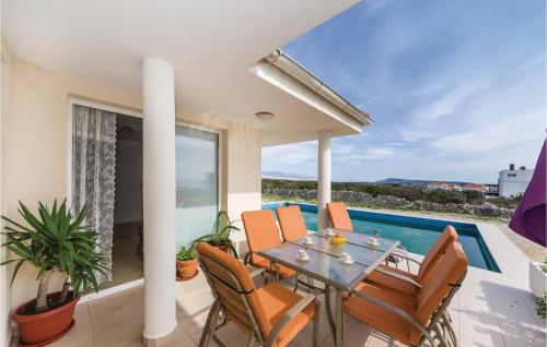 a patio with a table and chairs and a swimming pool at 3 Bedroom Lovely Home In Novalja in Novalja
