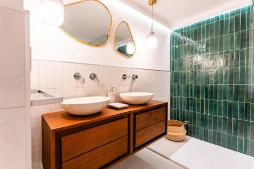 a bathroom with two sinks on a wooden vanity with a mirror at Nel Blu Dipinto Di Blu in Simius