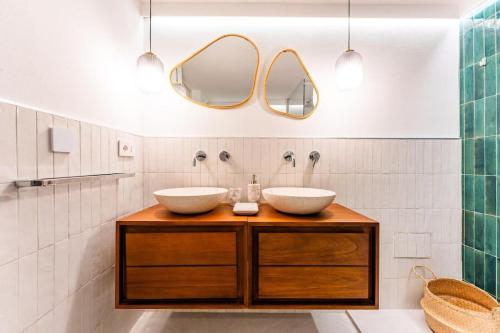 a bathroom with two sinks and two mirrors at Nel Blu Dipinto Di Blu in Simius