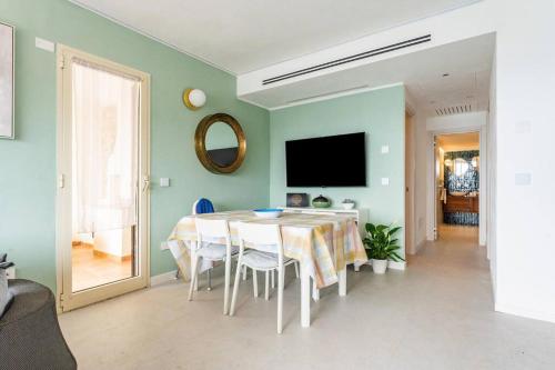 a dining room with a table with chairs and a television at Nel Blu Dipinto Di Blu in Simius
