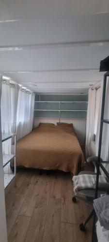 a bedroom with a bed with curtains and a wooden floor at Viking in Egmond aan Zee