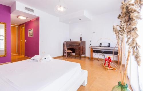 a bedroom with a white bed and a piano at Amazing Apartment In Lorca With Wifi in Lorca