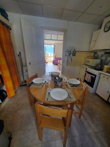 une cuisine avec une table en bois et des plaques de cuisson. dans l'établissement Chez Caroline, à Briançon