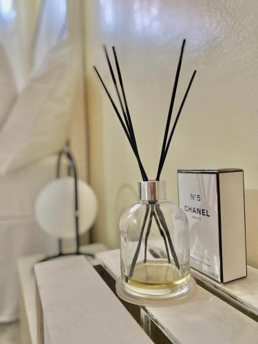 eine Glasvase mit Stöcken auf dem Tisch in der Unterkunft Luna Loft in Mondesa