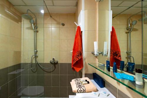 une salle de bain avec une douche, un lavabo et un miroir dans l'établissement Petar Apartment-City Center, Ohrid, à Ohrid