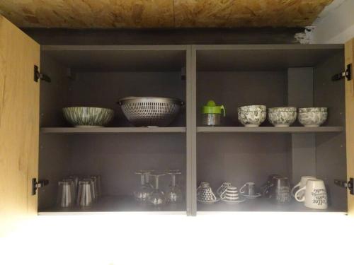 un meuble de cuisine rempli de bols et d'autres articles de cuisine dans l'établissement Loft industriel Marseille, à Marseille