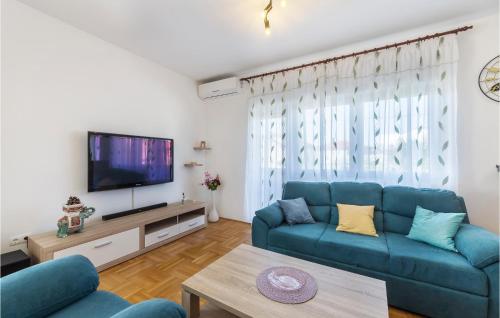 Una sala de estar con un sofá azul y un televisor. en Apartman Magno Mare, en Pula