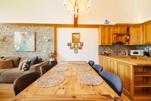 a living room with a wooden table and a kitchen at Villa Eliyas with Jacuzzi near the Pirin Golf Resort in Razlog