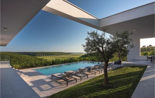 a pool with lounge chairs and a tree in a house at Villa Kalipso in Nova Vas