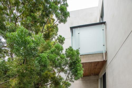 a window on the side of a building with trees at SIRTAJ – Beverly Hills in Los Angeles