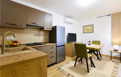 a kitchen with a table and a refrigerator and a table and chairs at Stunning Home In Ivanska in Ivanska