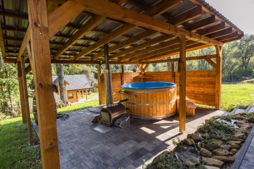 a wooden pergola with a hot tub in a yard at Niedźwiedzia Dolina in Przybyszów