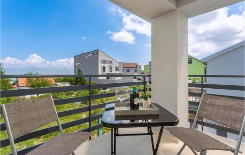 a balcony with a table and chairs with a view at Awesome Apartment In Vrbnik With Wifi in Vrbnik