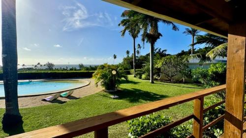 a view of a yard with a pool and palm trees at Moemiti in Moorea